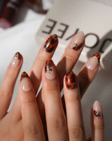 Handmade Pumpkin Patch press-on nail set with nude base amber tortoise swirls and gold accents