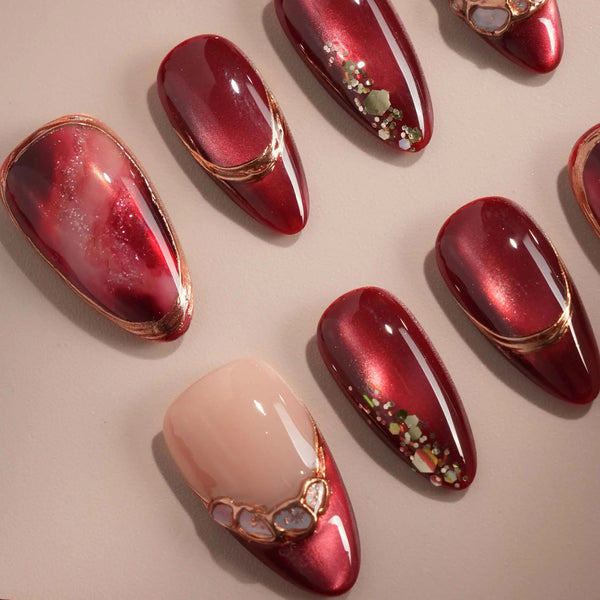 Red cat-eye press-on nails with gold shimmer