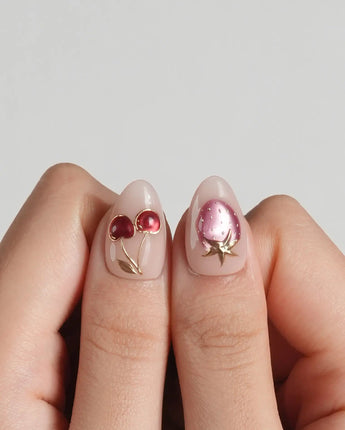 Crystal Berry press-on nails with nude base, red cat-eye cherries and dimensional gold accents