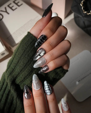 Relic press on nails in smoke grey and bone white with black marble veins, a silver starburst, a sculpted silver cross and a spiral - image 5