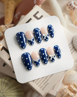 Sailor Dot short almond press-on nails with navy dots and refined nude accents