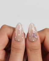 Salt & Sand custom-size beach nails with sandy nude polish and shiny sea charms