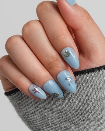 Sea Chrome close-up of metallic sea creature charms on glossy blue gel nails