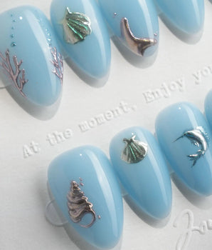 Sea Chrome 3D ocean nails with chrome dolphin, shells, coral, and tiny silver fish