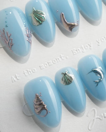 Sea Chrome 3D ocean nails with chrome dolphin, shells, coral, and tiny silver fish