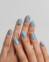 Sea Chrome extra short almond nails with cornflower-blue base and metallic ocean charms
