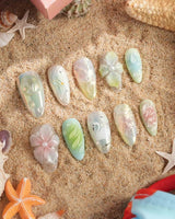 Seaglass Swan lagoon-inspired nails with cool blue-green glow and floral accents