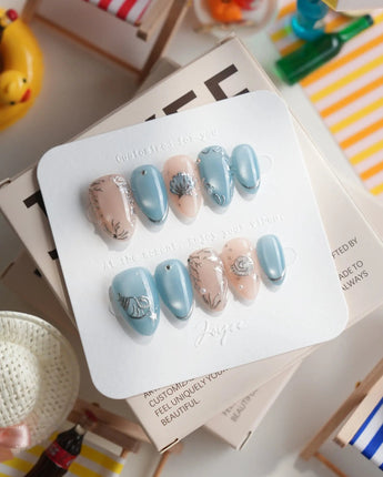 Shell Money extra short almond nails with metallic shell charms and beach-luxe shine