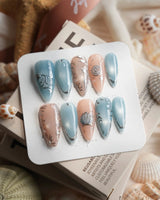 Shell Money medium stiletto nails with silver seashells and pearlescent ocean accents
