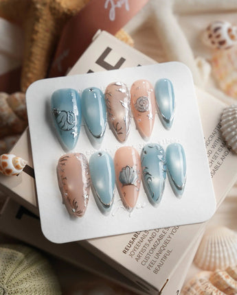Shell Money medium stiletto nails with silver seashells and pearlescent ocean accents