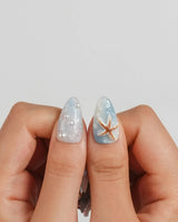 Shell Picking handmade blue jelly nails with aurora shimmer and scattered sea charms