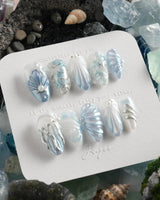 Great Barrier Blue deep-sea nails with pearlescent shell texture and flowing silver waves