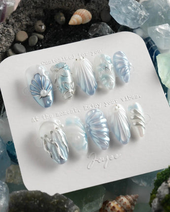 Great Barrier Blue deep-sea nails with pearlescent shell texture and flowing silver waves