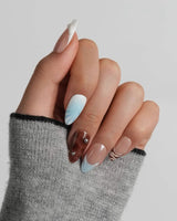 Shore Blend short almond nail set with warm nude, creamy white, and dark rock tones