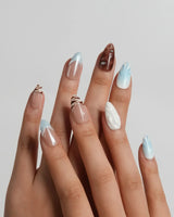 Shore Blend short almond nails with wet sand, icy blue water, white foam, and rock tones