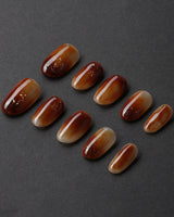 Onyx Shine in short oval shape with amber marble nails and glossy gel depth