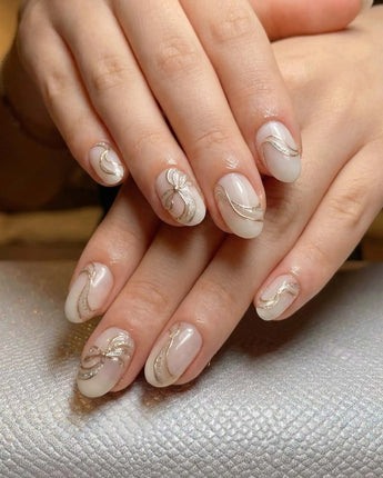 Silk Bow press-on nails in short oval shape — Luxury Creamy White & Gold, 3D Champagne Gold Wire Bows & Fine Shimmer.