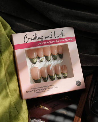 Close-up of Silk Green nails with dark cat-eye glow, French tips, and fine gold wire detail