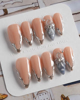 Silver Shore medium stiletto nails with nude silver chrome and 3D metallic flower