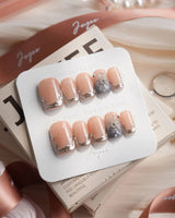 Silver Shore short square nails with nude base, silver chrome French tips, and floral detail