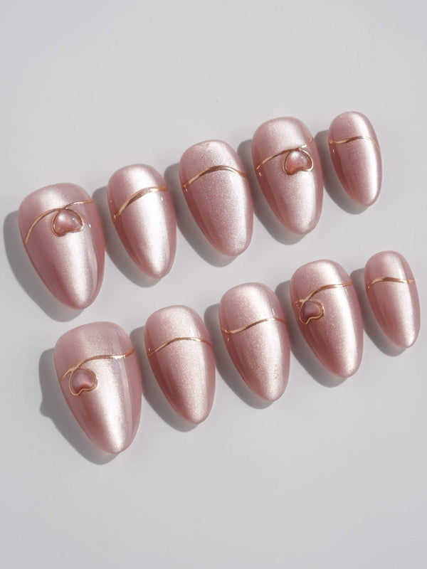 Romantic press-on nails with pink shimmer and gold-lined hearts
