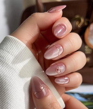 Simple love handmade press-on nails featuring Gentle Blush Cat Eye, Simple Gold Lines & 3D Hearts.