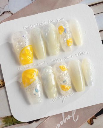 Slushie Lemon press-on nails with pale icy blue, white glitter, and juicy lemon details