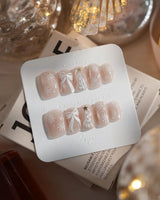 Snowfall press-on nails in extra short square shape — pearl nude cat eye snowflake bow silver glitter soft sheen