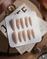 Spiral Twist in medium stiletto shape with pearly nude texture and daisy accents