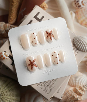 Starfish & Dots minimalist nails with ivory base, brown dots, and 3D starfish