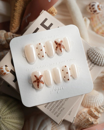 Starfish & Dots minimalist nails with ivory base, brown dots, and 3D starfish