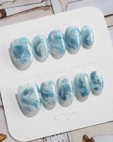 Starry River extra short oval nails with watery blue swirls and silver shimmer accents