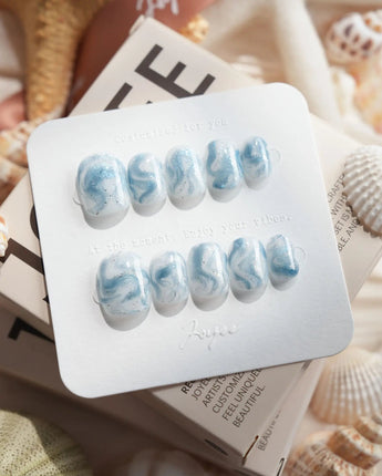 Starry River extra short squoval nails with blue-white marble flow and glossy aqua shine