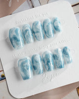 Starry River short coffin nails with blue-white marble swirls and shimmering cat-eye finish