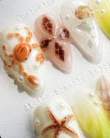 Sun Fossil ivory and lemon-yellow press-on nails with sun-baked shell accents