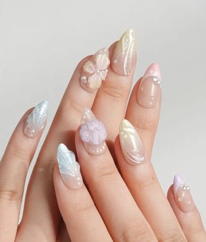Sunbathing pastel island nails with macaron base, sheer chrome, and sculpted shells