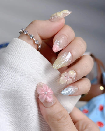 Sunbathing close-up of glossy pastel florals, shell details, and iridescent nude gel
