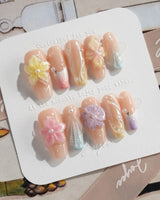 Sunbathing golden-hour nails with iridescent nude base and sculpted floral shine