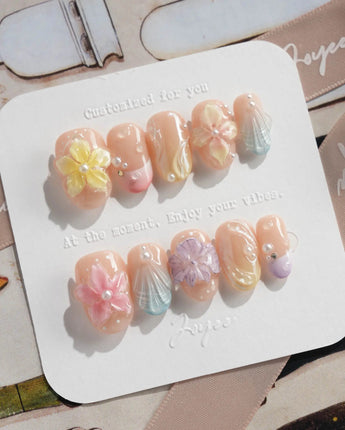 Sunbathing glossy pastel nails with oversized flowers and sunlit shell accents