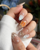 Sunset Shore beach vacation nails with coral glow, raised flowers, and glossy waves