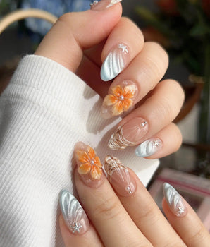 Sunset Shore tropical sunset nails with sculpted florals, silver waves, and seashell details