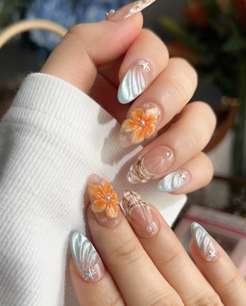 Sunset Shore tropical sunset nails with sculpted florals, silver waves, and seashell details