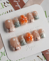 Sunset Shore short square nails with sculpted flowers, silver wave lines, and coral tones