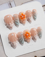 Sunset Shore short stiletto nails with coral sunset palette and sculpted shell details