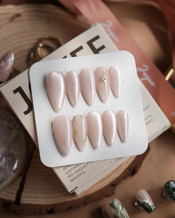 Sweet Nothings press-on nails in medium stiletto shape — Soft Nude Pink, Glitter Accents, Metal Heart & Silver Flowers.