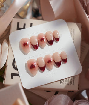 Sweet Venom handmade press-on nails featuring Ruby Red French, gold Outlines, 3D Red Hearts & Shimmering Lines.