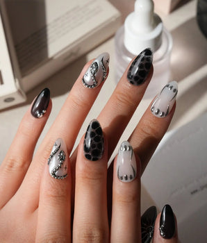 Talisman press on nails with a raised silver spiral sun on black, chrome white, glitter web print and a pearl nail crossed with silver beads - image 2