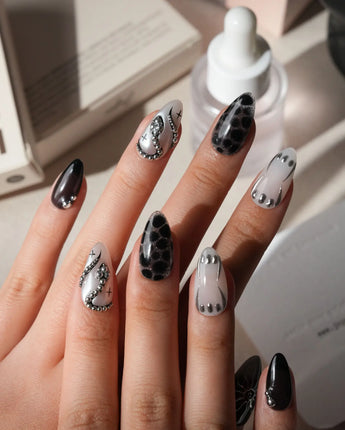 Talisman press on nails with a raised silver spiral sun on black, chrome white, glitter web print and a pearl nail crossed with silver beads - image 2