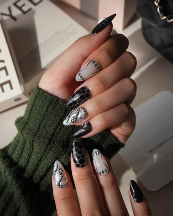 Talisman press on nails with a raised silver spiral sun on black, chrome white, glitter web print and a pearl nail crossed with silver beads - image 4