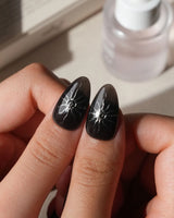 Talisman press on nails with a raised silver spiral sun on black, chrome white, glitter web print and a pearl nail crossed with silver beads - image 5